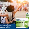 Zwei Personen mit erhobenen Armen und Getränken in der Hand auf einem Festival oder Outdoor-Event, von hinten fotografiert. Im Vordergrund sind zwei Packungen des pflanzlichen Erkältungsmittels Imupret® N von Bionorica zu sehen: Dragees (50 Stück) und Tropfen. Text im Bild: „Wenn man nichts verpassen will...“