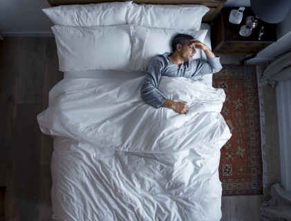 Mann mit Erkältung im Bett