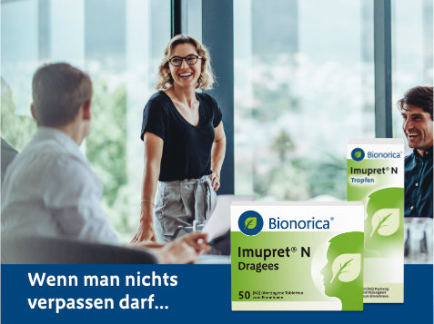 Drei Personen im Gespräch, zwei sitzen, eine steht – alle Gesichter sind unscharf dargestellt. Im Vordergrund befinden sich zwei Packungen des pflanzlichen Erkältungsmittels Imupret® N von Bionorica: Dragees und Tropfen. Text im Bild: „Wenn man nichts verpassen darf...“